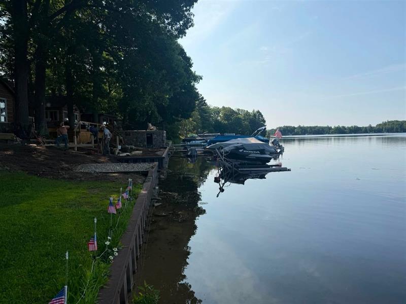 Wide view of a completed seawall along a calm lake shoreline