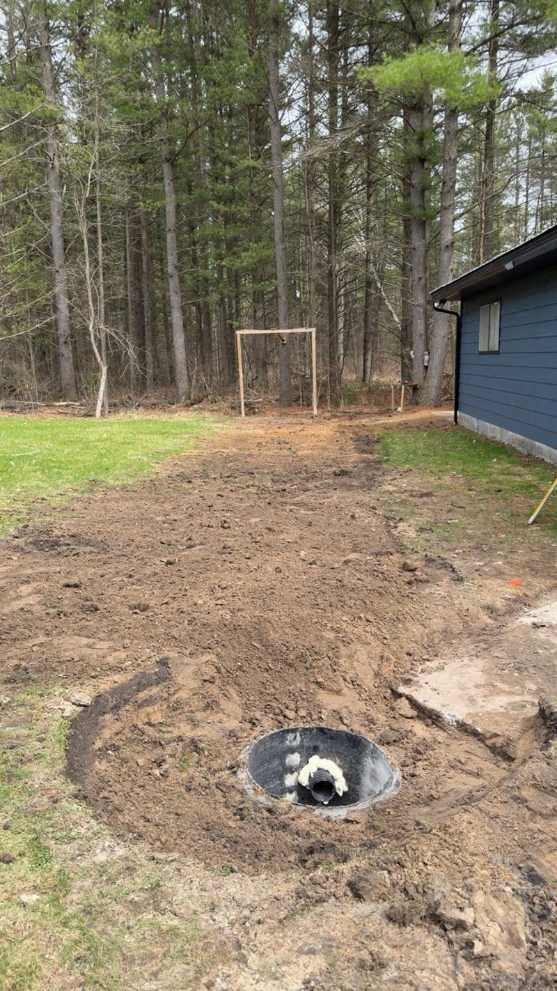 Backfilled trench and new septic tank riser