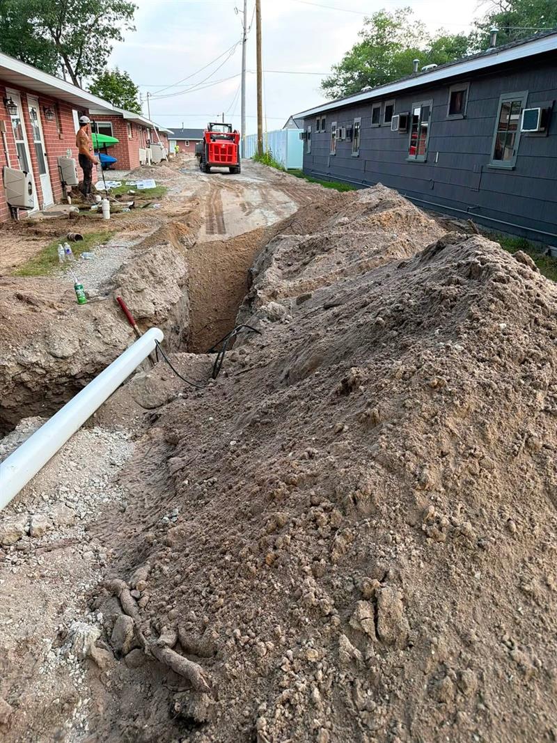 Sewer line replacement trench between buildings