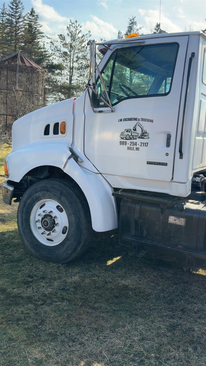 Lettered JW Excavating and Trucking truck door